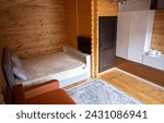 Small photo of The cabins interior is paneled with wood and furnished with a bed, sofa, and armoire. A bearskin rug adds a touch of warmth to the space.