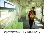Small photo of MUMBAI/INDIA - MAY 28, 2020: A worker sprays disinfectant to sanities a monorail as a preventive measure against the COVID-19 corona virus. MMRDA is preparing to resume its services.