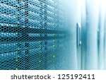 Abstract of modern high tech internet data center room with rows of racks with network and server hardware.