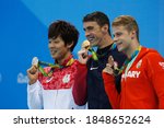 Small photo of Rio de Janeiro, Brazil 08/09/2016: Michael Phelps gold medal at Rio 2016 Olympic Games 200m butterfly swim podium. Japan's Masato Sakai silver, Hungary's Tamas Kenderesi bronze at Aquatic Stadium