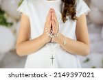 Small photo of Hands of the First Communion girl folded in prayer. First Holy Communion. A girl in a white communion dress after receiving her First Holy Communion