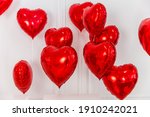 White background with red hearts balloons with helium.