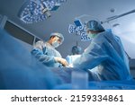Small photo of Surgical team making operation in sterile medical room