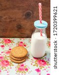 Small photo of some oatmeal cookies with retro milk bottle, and naif flowery background