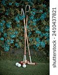Small photo of Croquet Mallets amongst blue flowers