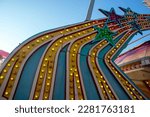 bold bright colorful light bulbs on amusement park ride shaped like shooting stars shot outdoors in natural light blue sky background with copy space