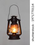 Small photo of old vintage rusty kerosene black lamp isoleted on gray background. Glass oil lamp. Storm lantern. object vintage concept