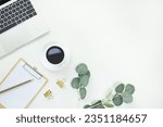 Small photo of Top view office table desk workspace frame with green leaves eucalyptus, clipboard and coffee cup isolated on white background. Flay lay, ideas, notes or plan writing concept