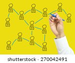 Businessman is drawing social network concept with marker on transparent board with yellow background.