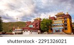 Small photo of Tibetan architecture. Traditional tibetan house in the sunlight and blue sky with clouds background. House with tibetan symbols and ornaments in Sichuan province, China.