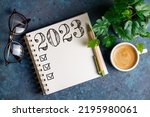 New year resolutions 2023 on desk. 2023 resolutions list with notebook, coffee cup on table. Goals, resolutions, plan, action, checklist concept. New Year 2023 template, copy space