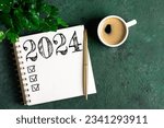 Small photo of New year resolutions 2024 on desk. 2024 resolutions list with notebook, coffee cup on table. Goals, resolutions, plan, action, checklist concept. New Year 2024 template, copy space