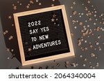 Small photo of Letter board with text 2022 say yes to new adventures. Motivational quote, new year goals and resolution concept. Flat lay, top view