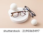 Stylish eyeglasses over pastel background. Optical store, glasses selection, eye test, vision examination at optician, fashion accessories concept. Top view, flat lay