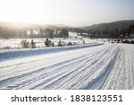 tire tracks in the snow, winter road, empty road in winter goes far to the horizon, covered with snow path, winter landscape
