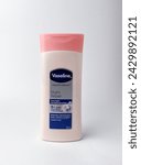 Small photo of Jakarta, Indonesia - February 25th, 2024 - Vaseline healthy bright night repair pink plastic bottle packaging. Body lotion skin care object photography isolated on white plain background.