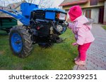 Little Girl Near A Tractor A...