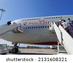 Small photo of Pathos. Cyprus. 10.24.2021. Passengers boarding a double-decker plane of Rossiya Airlines at the Cyprus airport in Paphos on a sunny day using two ladders.