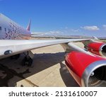 Small photo of Pathos. Cyprus. 10.24.2021. Two red aircraft engines on the wing of a Rossiya airline plane standing at Paphos airport against a beautiful blue sky with clouds.