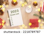 New Year Aims. 2023 To Do List writing. Writing in Empty Notebook at Wood Table with Christmas Decor. Top view. Creating Goal List, Resolutions. New Life, Start Up, Beginning Concept. Business ideas