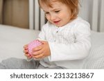 Cute baby girl playing tactile knobby balls. Young child hand plays sensory massage ball. Enhance the cognitive, physical process. Brain development. Support for Children with ADHD, autism, fidgeting.