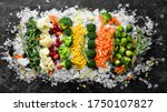 Assortment of frozen vegetables on ice. Stocks of food. Top view. Free space for your text.