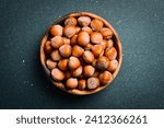 Small photo of Hazelnuts in a wooden bowl. Hazelnut nut health organic brown filbert autumn background concept. Close up.