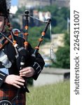 Small photo of A bagpiper busking with the Great Highland bagpipe on the street in Edinburgh, Scotland.