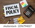 Small photo of fiscal policy text on notepad pages with tacky bookmarks and stickers. calculator and glasses