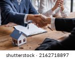 Small photo of Real estate brokerage agent Deliver a sample of a model house to the customer, mortgage loan agreement Making lease and buy and sell house And contract home insurance mortgage loan concept