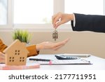 Small photo of Asian agent giving a key to new owner or tenant, client after signed signature contract rental purchase, buyer apartment, home with landlord, realtor. Banker agreement mortgage loan. Property lease.
