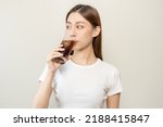 Small photo of Thirsty, attractive asian young woman, girl drink or sip, holding a glass of cold sparkling water with ice in hand, refreshness people, isolated on white background. Temptation of food, health care.