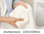 Small photo of Housewife, asian young woman hand in holding shirt, showing making stain, spot dirty or smudge on clothes, dirt stains for cleaning before washing, making household working at home. Laundry and maid.