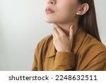 Small photo of Sickness in inflaming asian young woman, girl use hand check self touch at sore throat, pain thyroid gland on neck or disease reflux, acid of suffer people on wall background. Medical and healthcare.