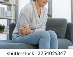 Flatulence caucasian mature adult, senior woman hand in stomach ache, suffer from food poisoning, abdominal pain and colon problem, gastritis or diarrhoea. Patient belly, abdomen or inflammation.