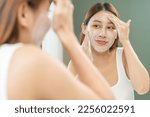 Small photo of Cheerful asian young woman, beauty girl hand applying foam cleanser for washing on her face, clean fresh healthy skin care, exfoliation scrub soap with cleansing product. Skincare spa relax concept.