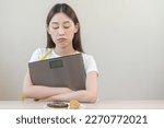 Small photo of Diet, dieting asian young woman expression face bored, looking at doughnut, bakery and fried chicken in plate to loss weight, hugging weight scales. Passion, temptation when hungry restrained to eat