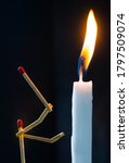 Small photo of Matchsticks in form of a man lighting a candle, matchstick man lighting a candle.