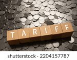 Small photo of Wooden blocks with "TARIFF" text of concept and coins.
