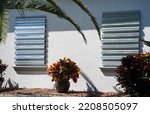 Small photo of Home prepares for hurricane by putting up storm shutters.