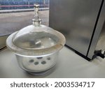 Small photo of Glass desiccator vacuum jar in a laboratory. A desiccator is a removable cover that contains a desiccant used to preserve moisture -sensitive items such as cobalt chloride paper for other uses.