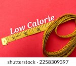Yellow measuring tape with the word Low Calorie on a red background  