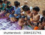 Small photo of New Delhi, India-Nov 3 2021: Group of Slum children sitting at charitable School eating Burger during celebration of school opening after long covid lockdown.