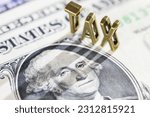 Small photo of Income tax, tax collection, financial concept : The word tax with a photo of US President George Washington on a one-dollar bill. Tax is a Compulsory payment to government based on income or wealth.