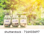 Saving money for house and car concept : Coins in three jars with label. Ideas of saving for a down payment on a car or home that allow buyers to use down payment to reduce overall cost of borrowing.