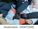 Small photo of little baby sleeping in the car transport seat. child restraint system, safety harness. safety and transportation concept in babies and children