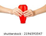 Small photo of Two hands are squeezing a bottle of ketchup. Squeeze out the ketchup. Isolate on a white background. Squeezing a red plastic bottle.
