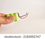 Small photo of A man is holding a NiMH battery on a white background