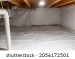 Small photo of Crawl space fully encapsulated with thermoregulatory blankets and dimple board. Radon mitigation system pipes visible. Basement location for energy saving home improvement
