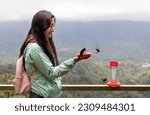 Small photo of woman in the middle of the jungle drinker a humming bird in mindo ecuador